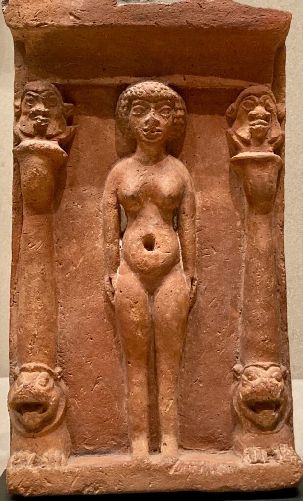 A small terra cotta relief sculpture of a woman standing between two columns.
