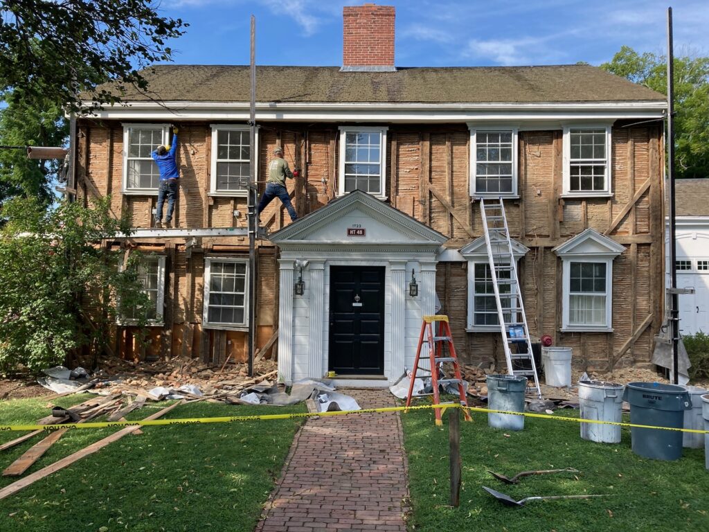 House with siding removed, which exposes the old timber framing