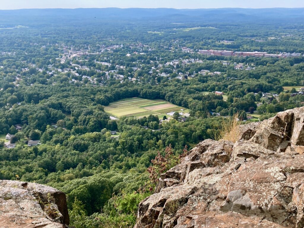 Rocky ledge in foreground, with view over a valley.