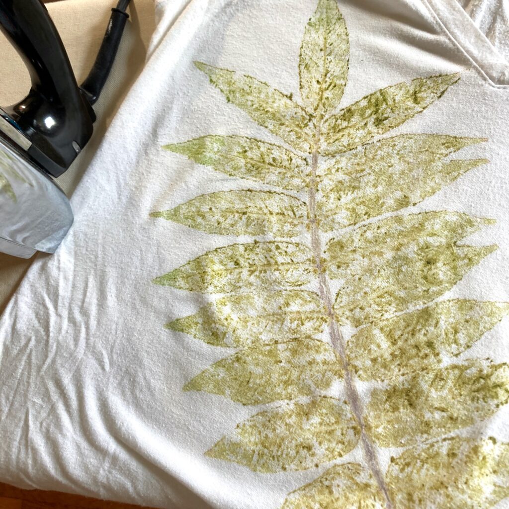 The leaf design on the cloth, with an electric steam iron sitting next to the cloth.