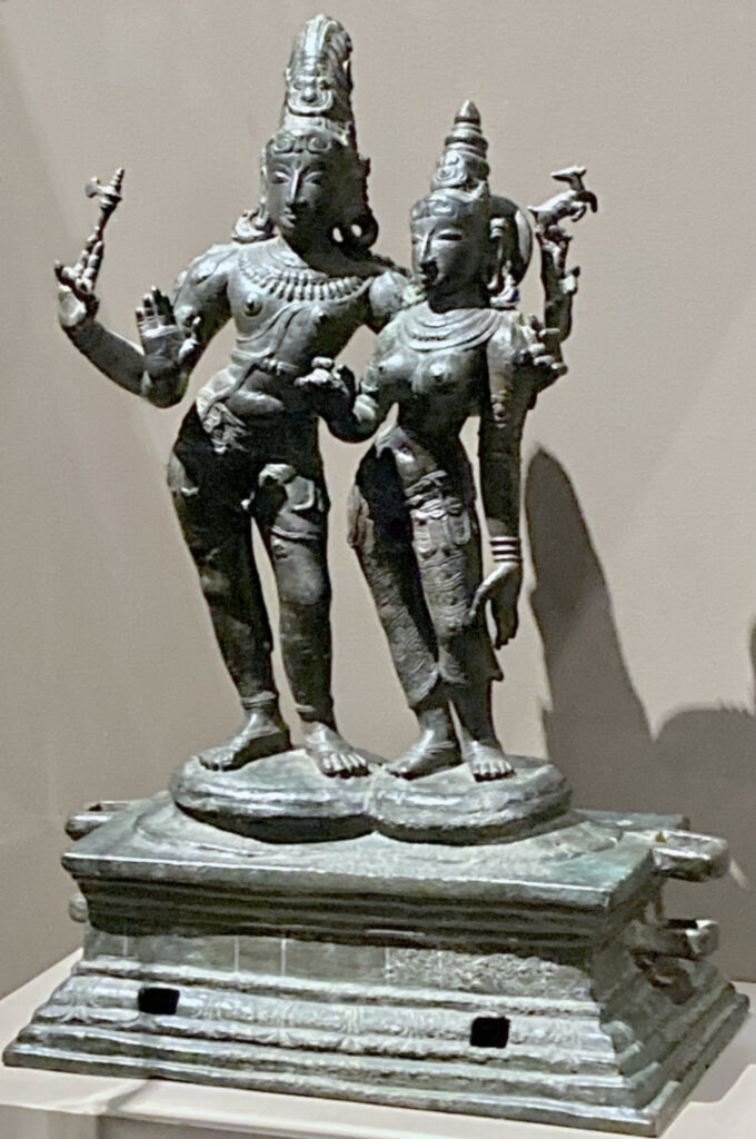 A sculpture of a male god with one of his four arms around a female goddess.