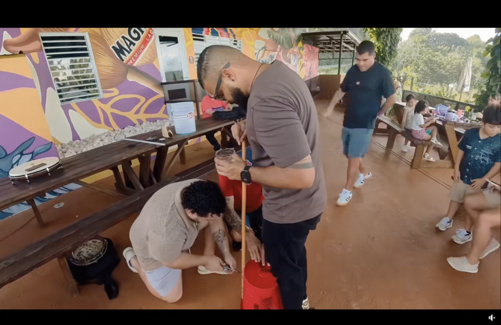 Two people making a tumbandero from a five gallon bucket.